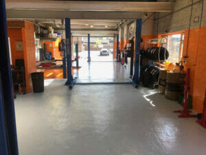 Grey two pack epoxy floor paint top coat applied to a working garage floor