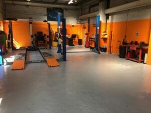 Grey two pack epoxy floor paint top coat applied to a working garage floor