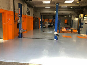 Grey two pack epoxy floor paint top coat applied to a working garage floor