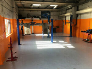 Grey two pack epoxy floor paint top coat applied to a working garage floor